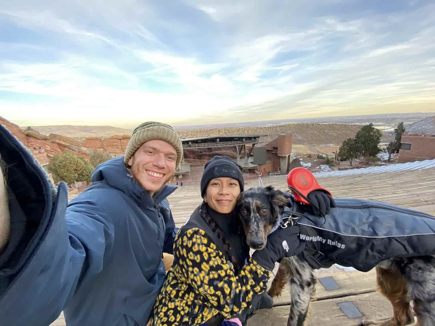 a man and woman taking a selfie with a dog