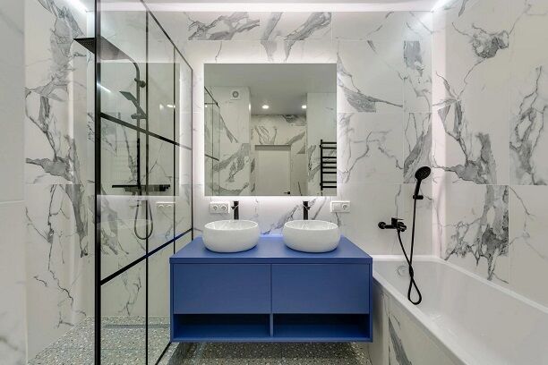 a bathroom with marble walls and a blue vanity